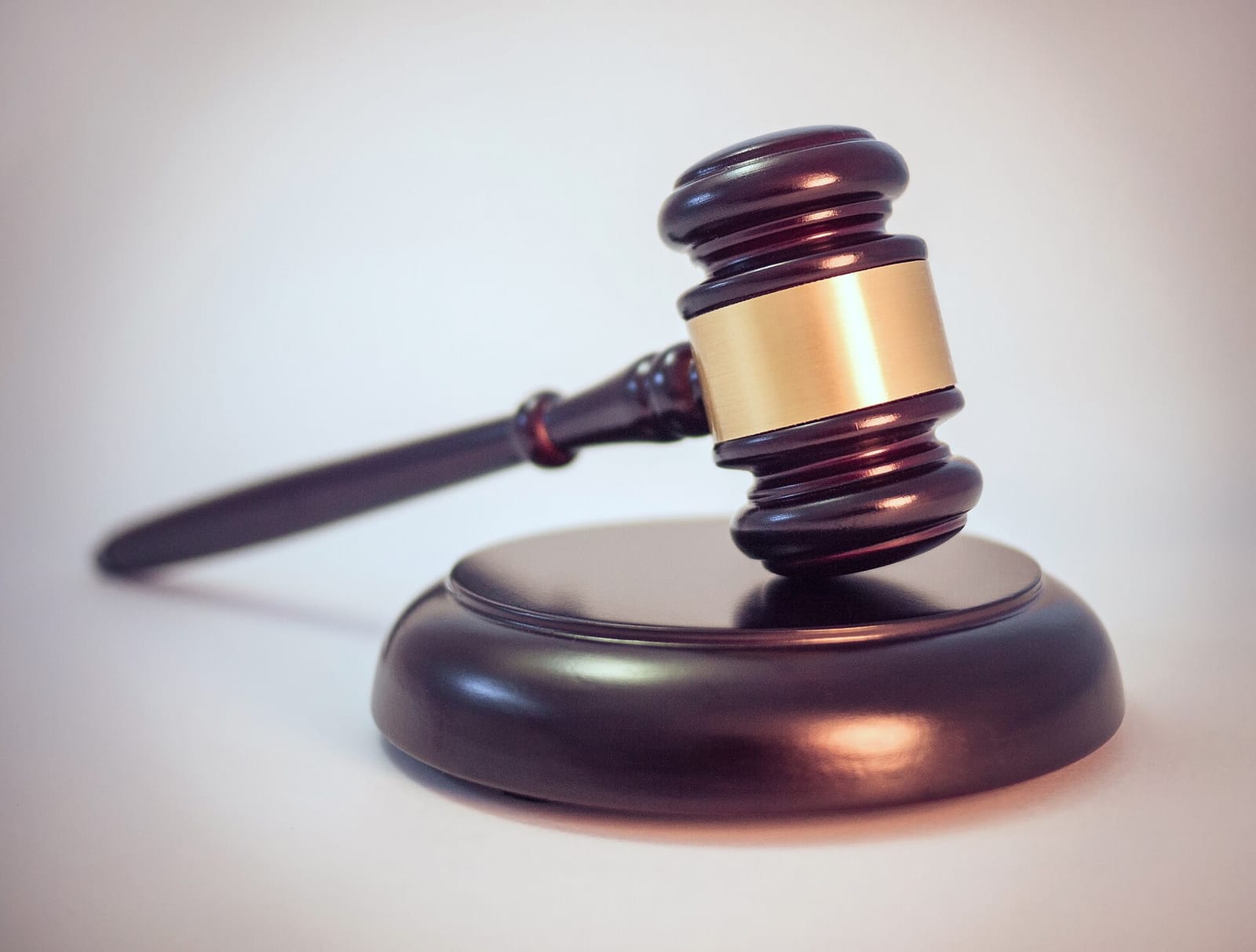 A wooden judge's gavel resting on its sound block