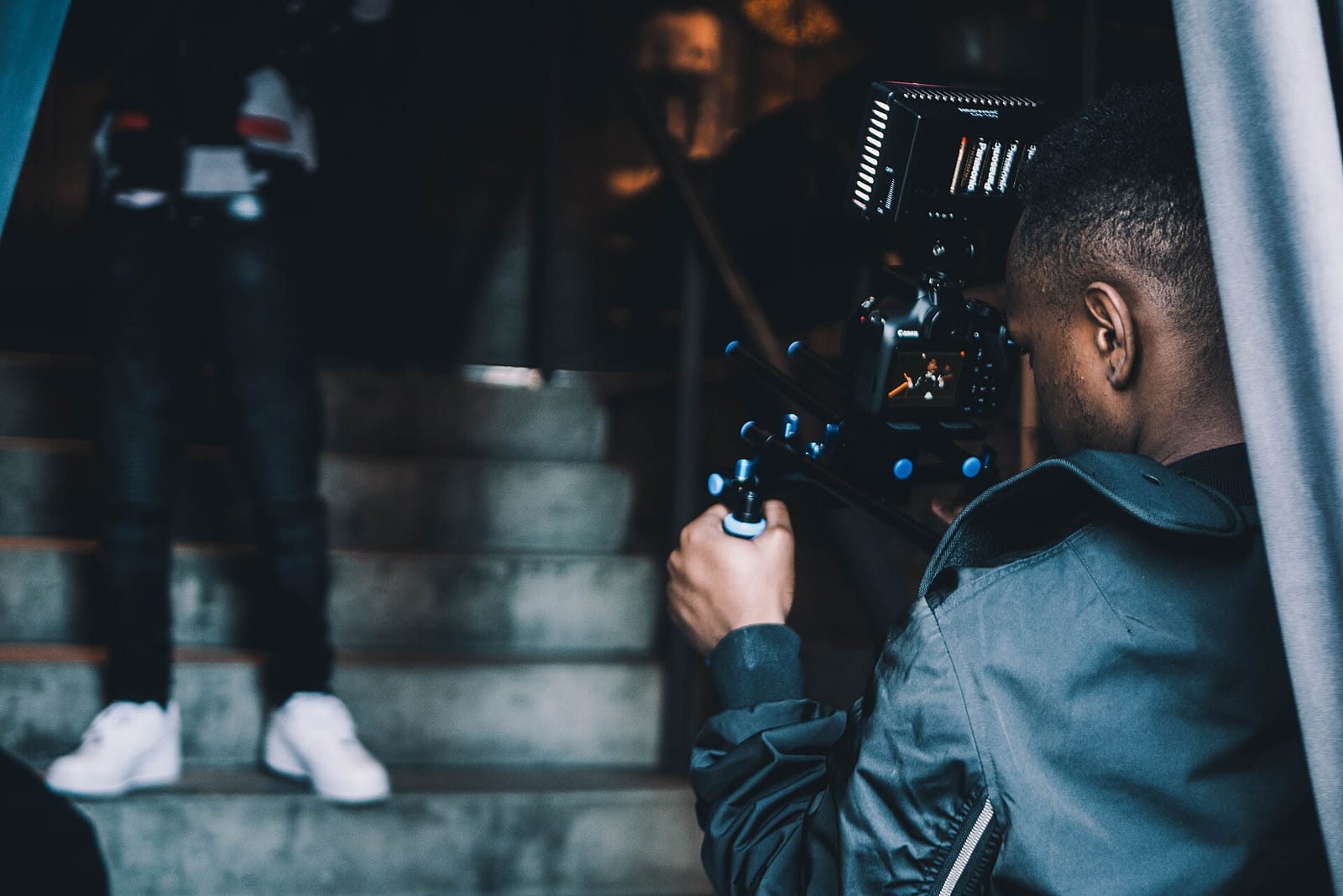 A videographer filming on a staircase with a stabilised camera rig