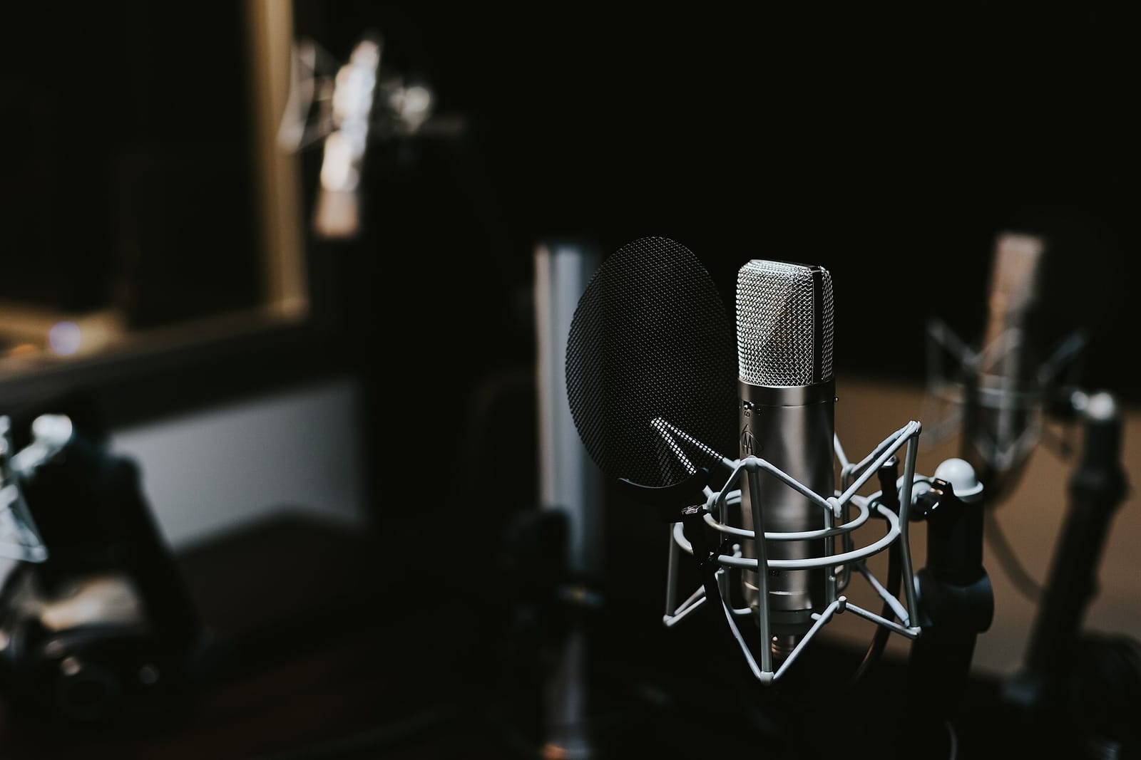 A condenser microphone with a pop filter in a recording studio