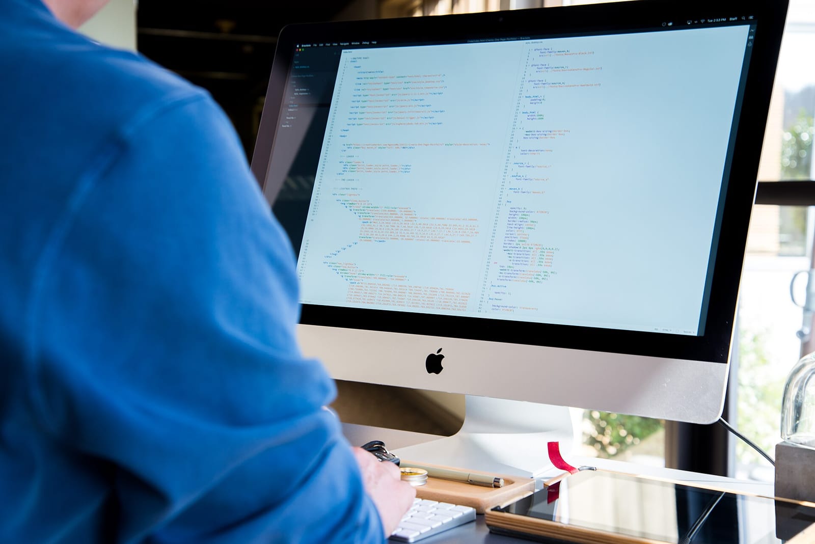 A developer working on code on a desktop computer
