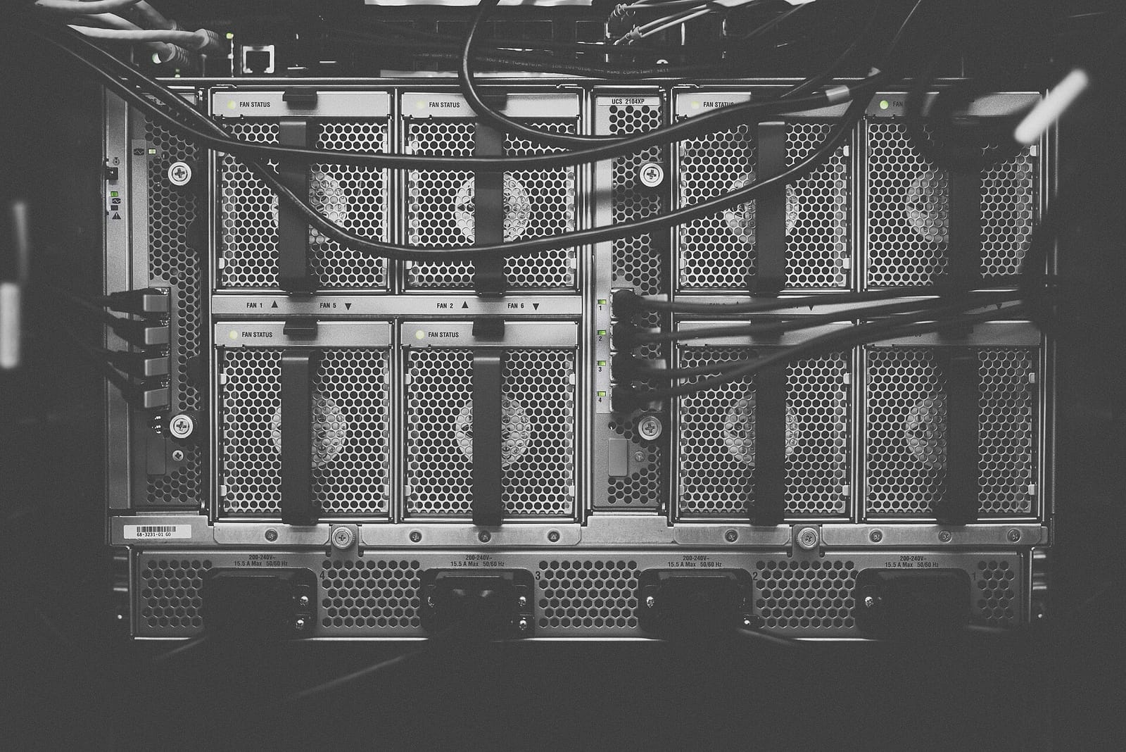 Black-and-white close-up of server hardware with drive bays and cables in a rack