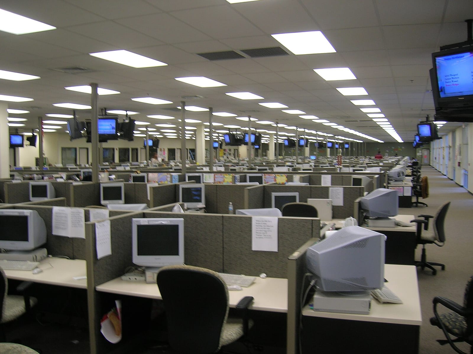 Rows of cubicles with computers and phones in a large call centre