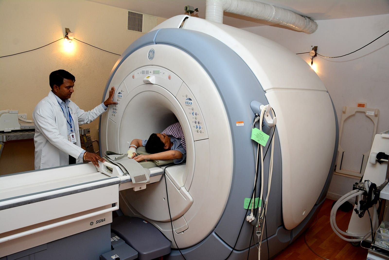 A technician preparing a patient for an MRI scan in a hospital