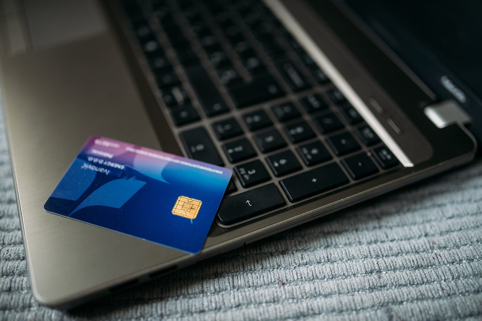 A bank card resting on an open laptop keyboard