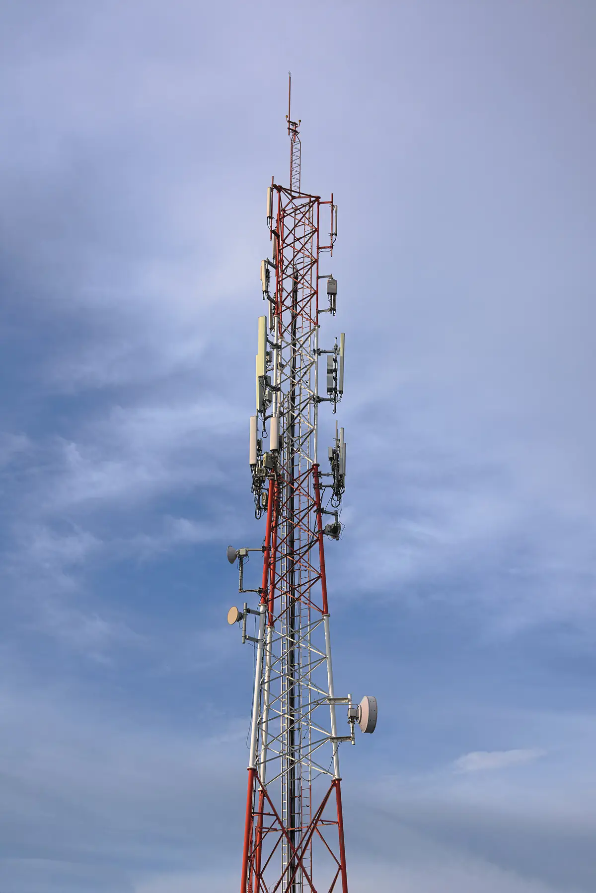 A cellular tower with antenna panels against the sky