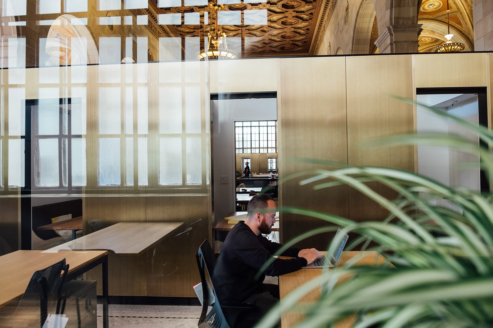People working on laptops at desks in an open-plan office