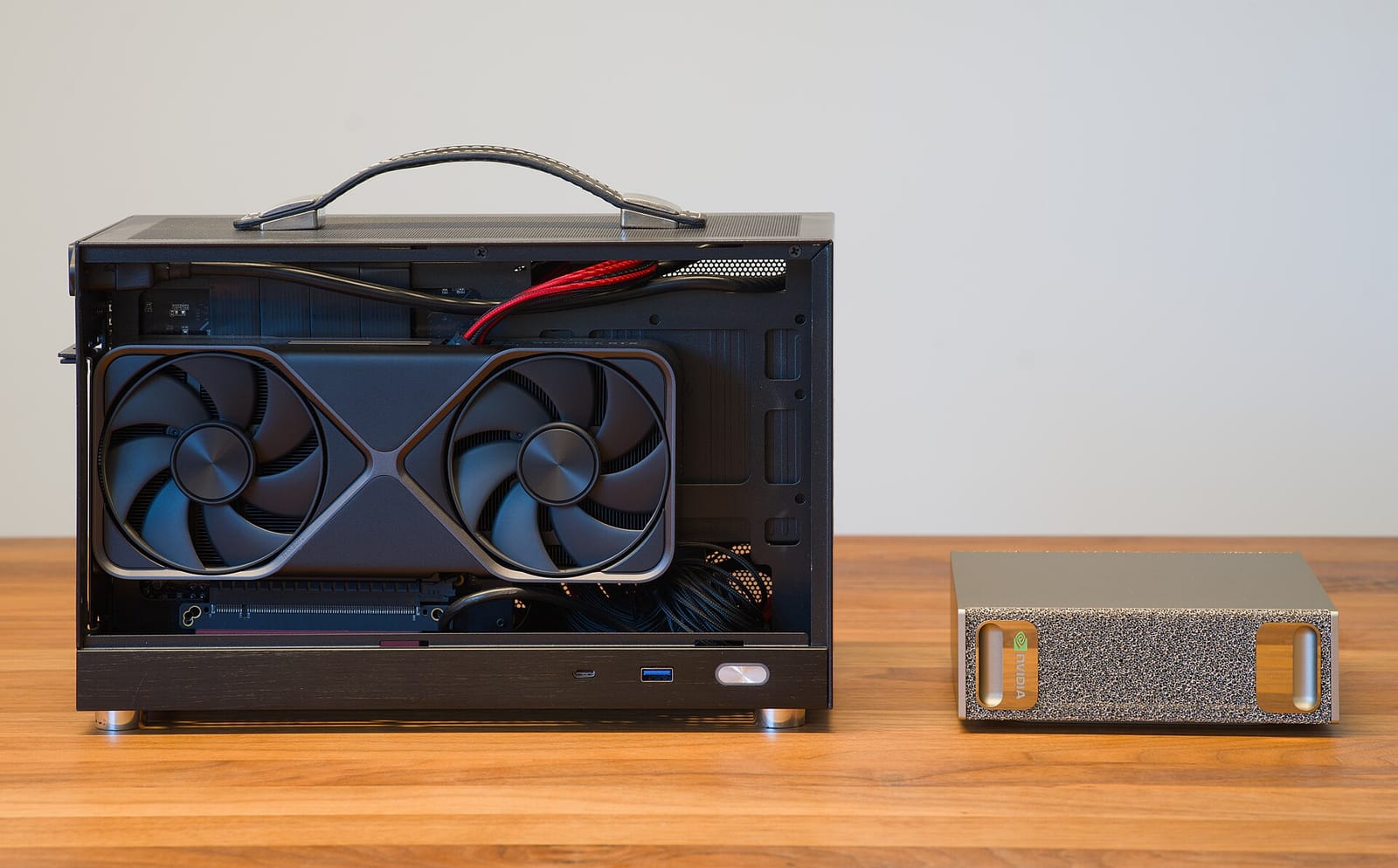 Small-form-factor PC with a GeForce RTX 5070 Founders Edition next to an NVIDIA DGX Spark