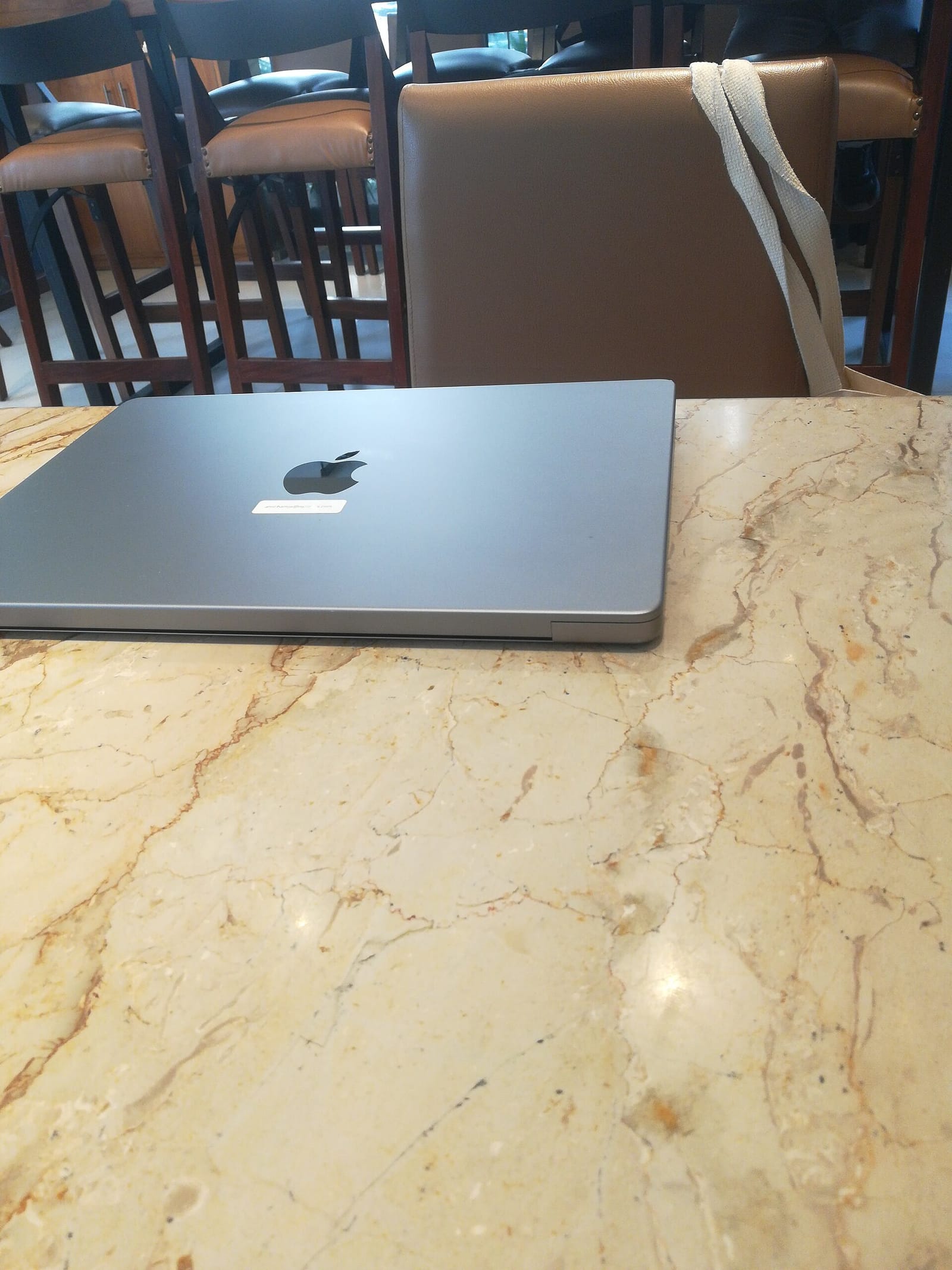 Closed Apple MacBook Pro with M3 chip on a marble table