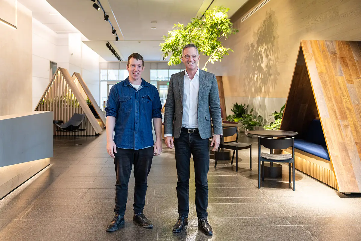 Two men standing in the wood-paneled lobby of Anthropic's San Francisco office