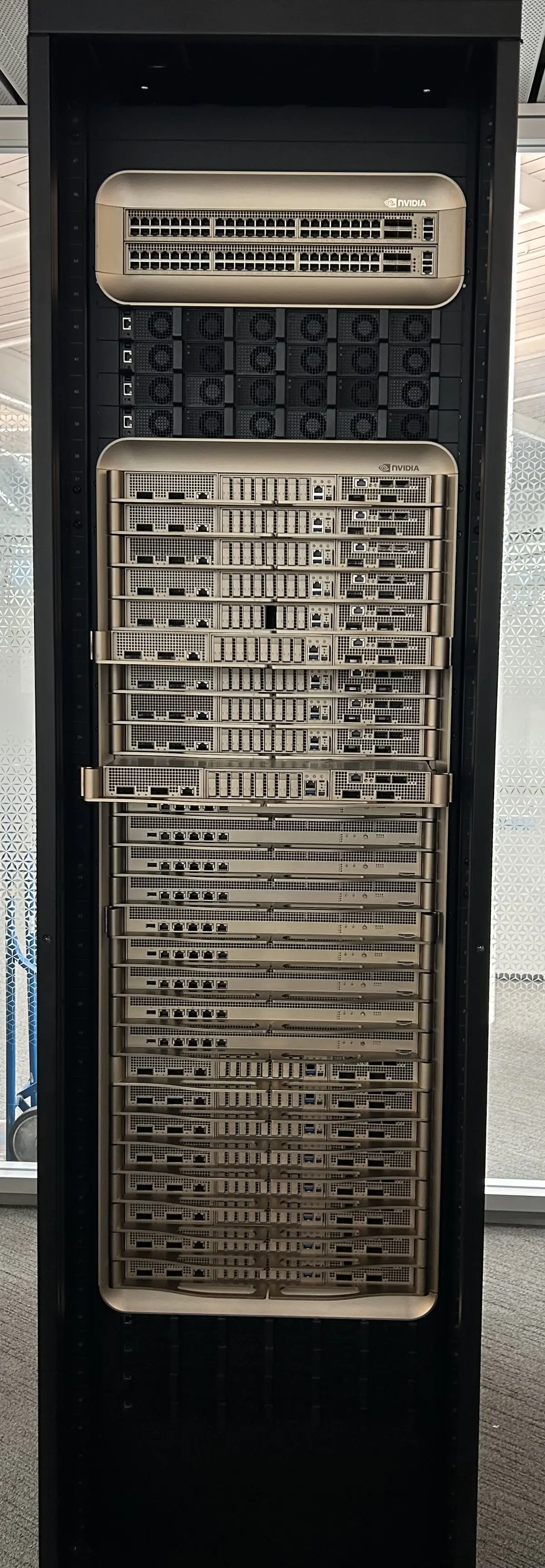 A tall black Nvidia GB200 server rack filled with stacked compute trays and switches