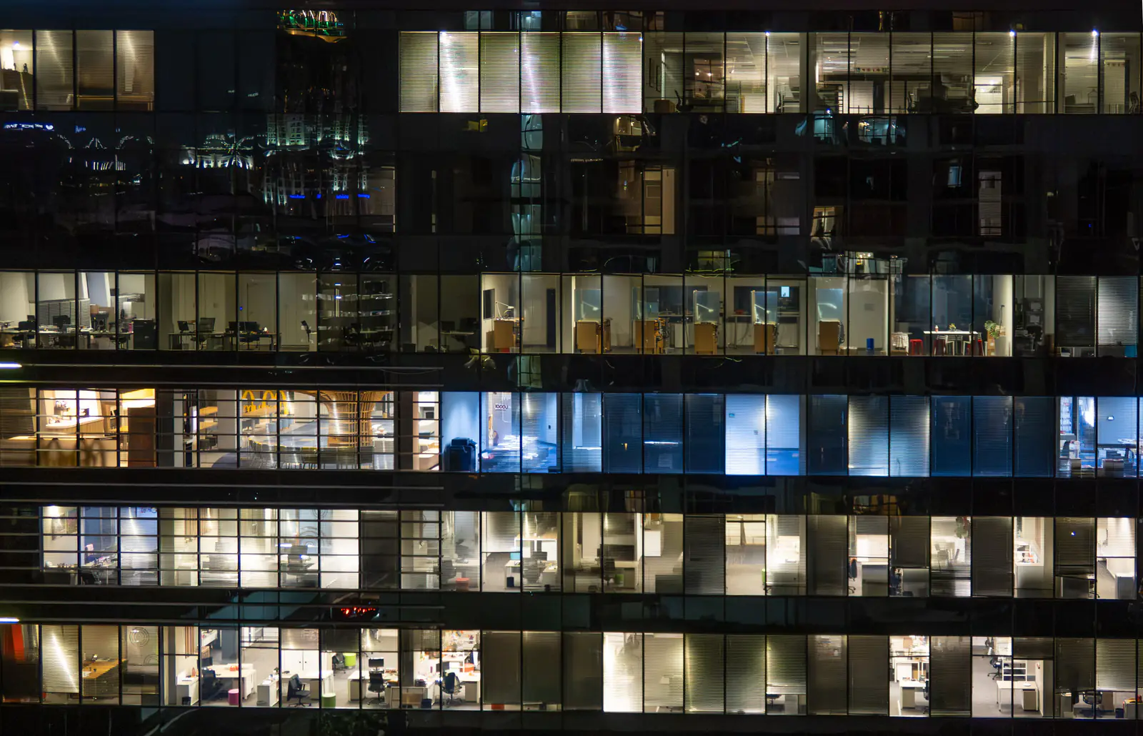 A city office building at night with its floors lit up