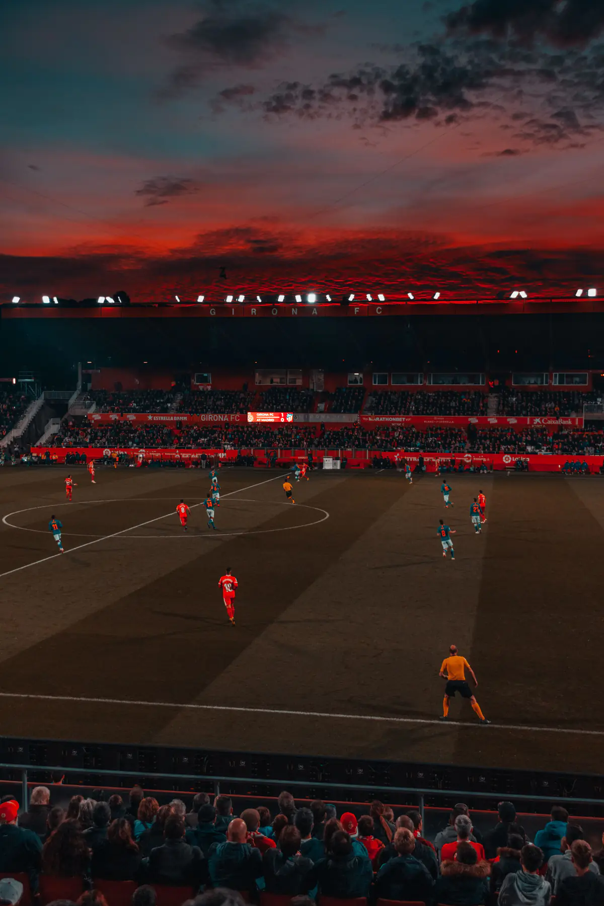 Players on a soccer field in a stadium at sunset